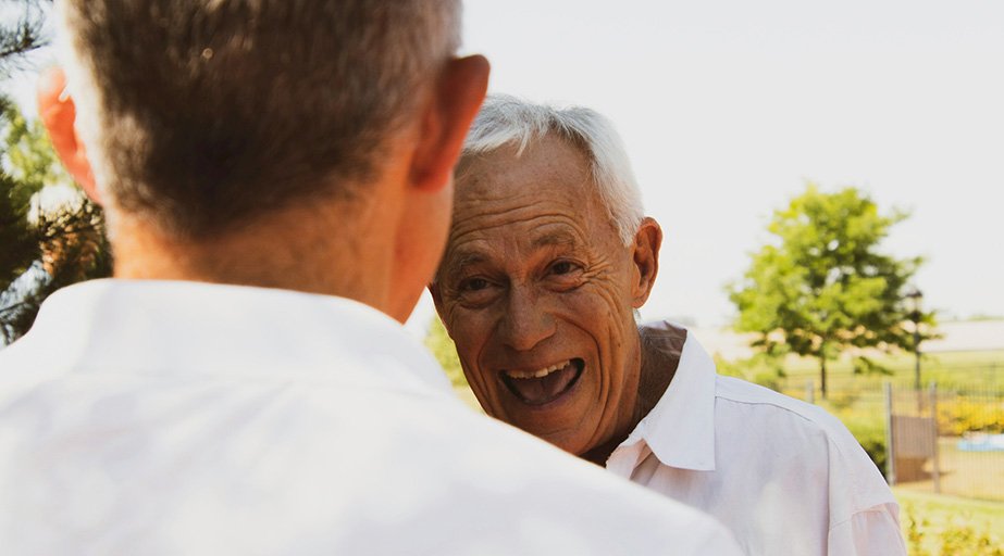 A smiling senior conversing outdoors.