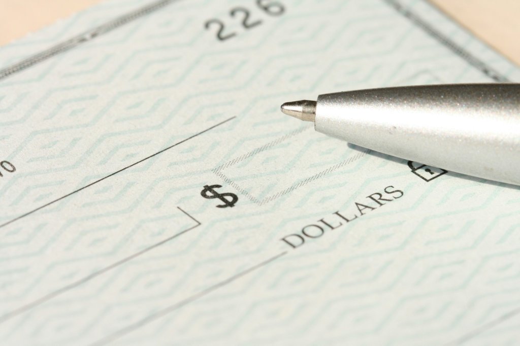 A closeup of a pen in front of a check