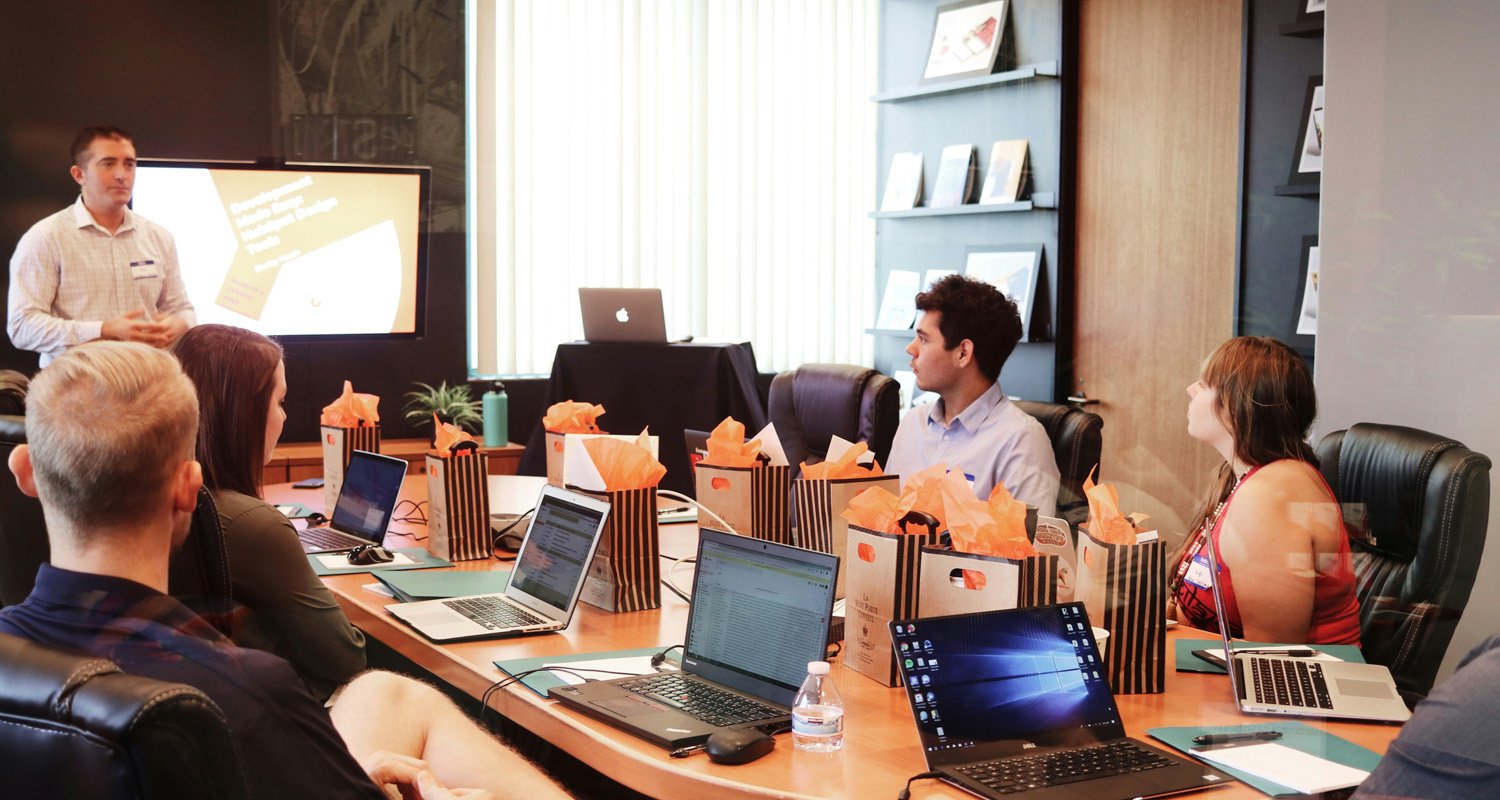 Professional business team in a modern office conversing around a table.