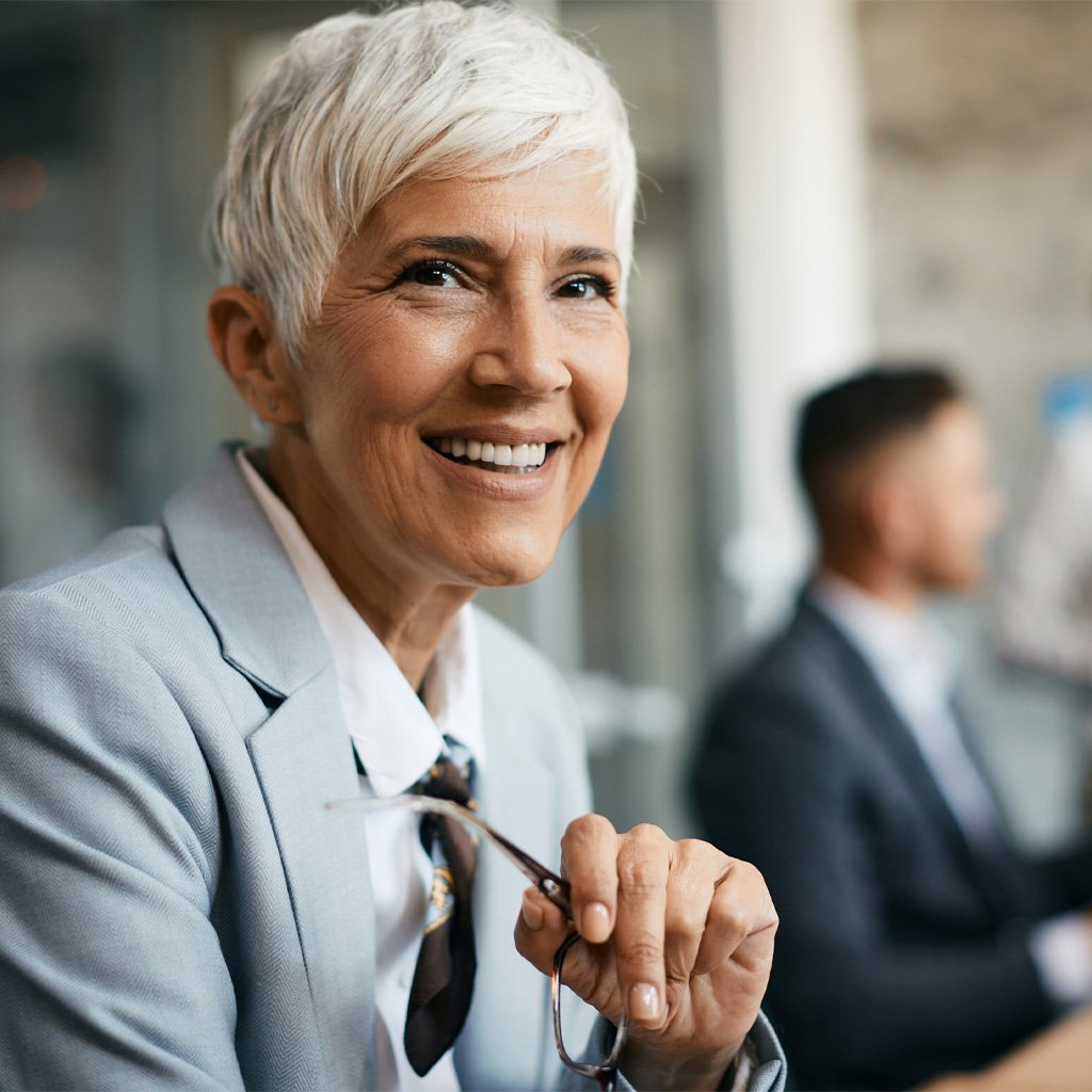 A woman in a business setting smiling.